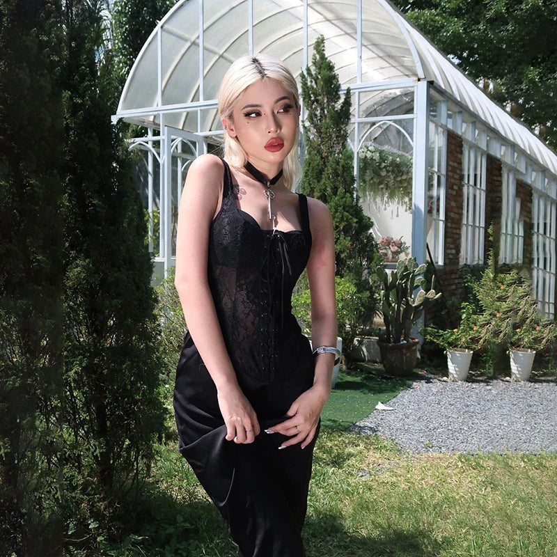 Kobieta ubrana w suknię gotycką stoi w ogrodzie